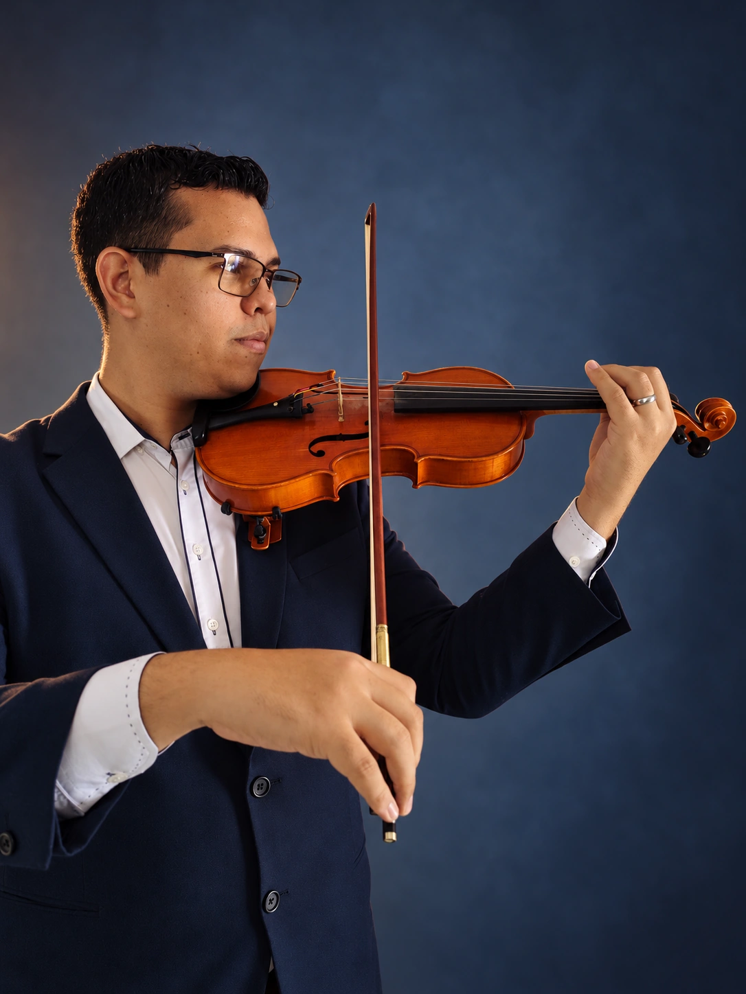 Retrato de estúdio do músico tocando violino, com expressão de concentração
