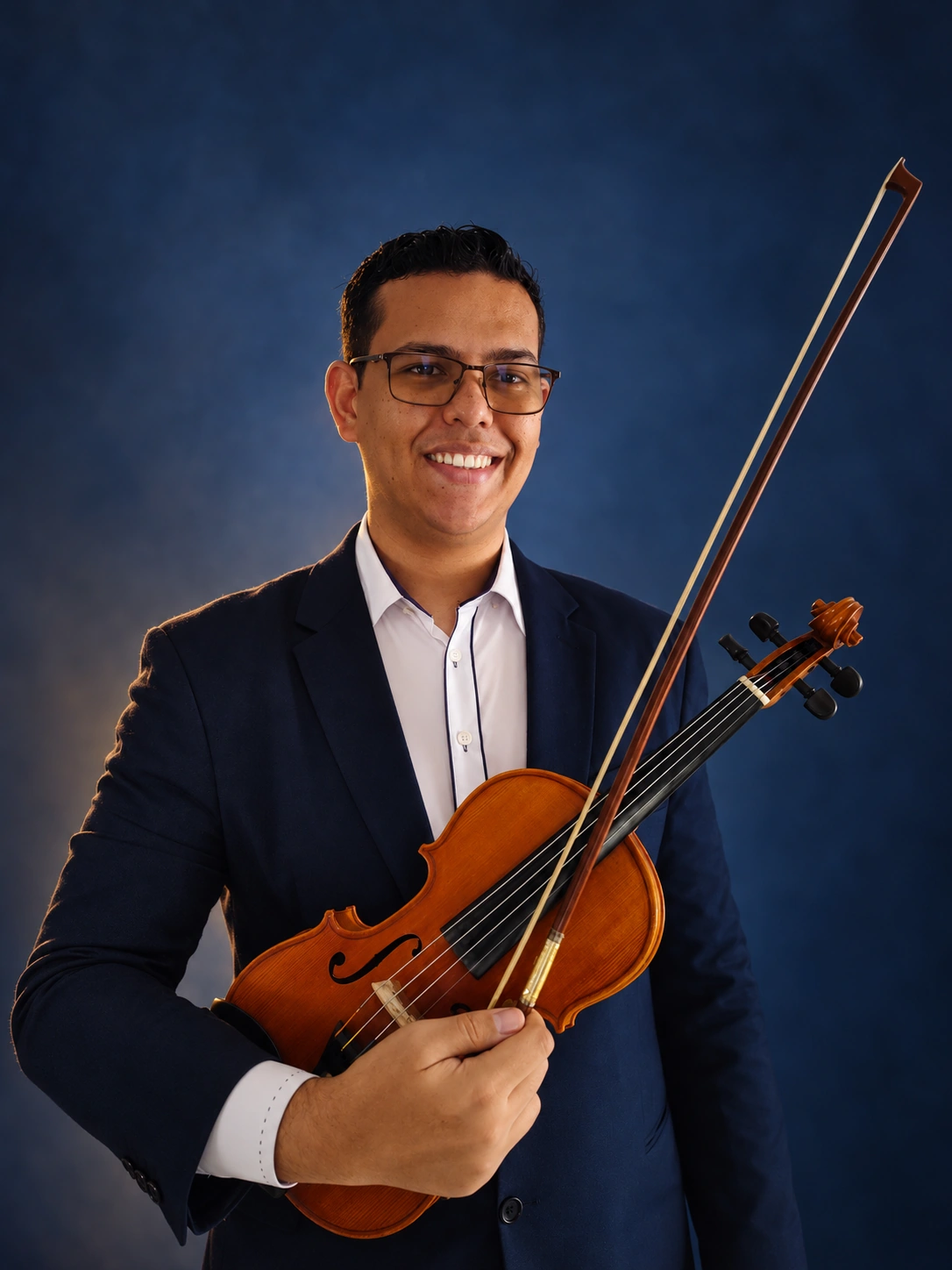 Retrato em fundo de estúdio azul do músico da VIDAL MUSIC, sorrindo com o violino
